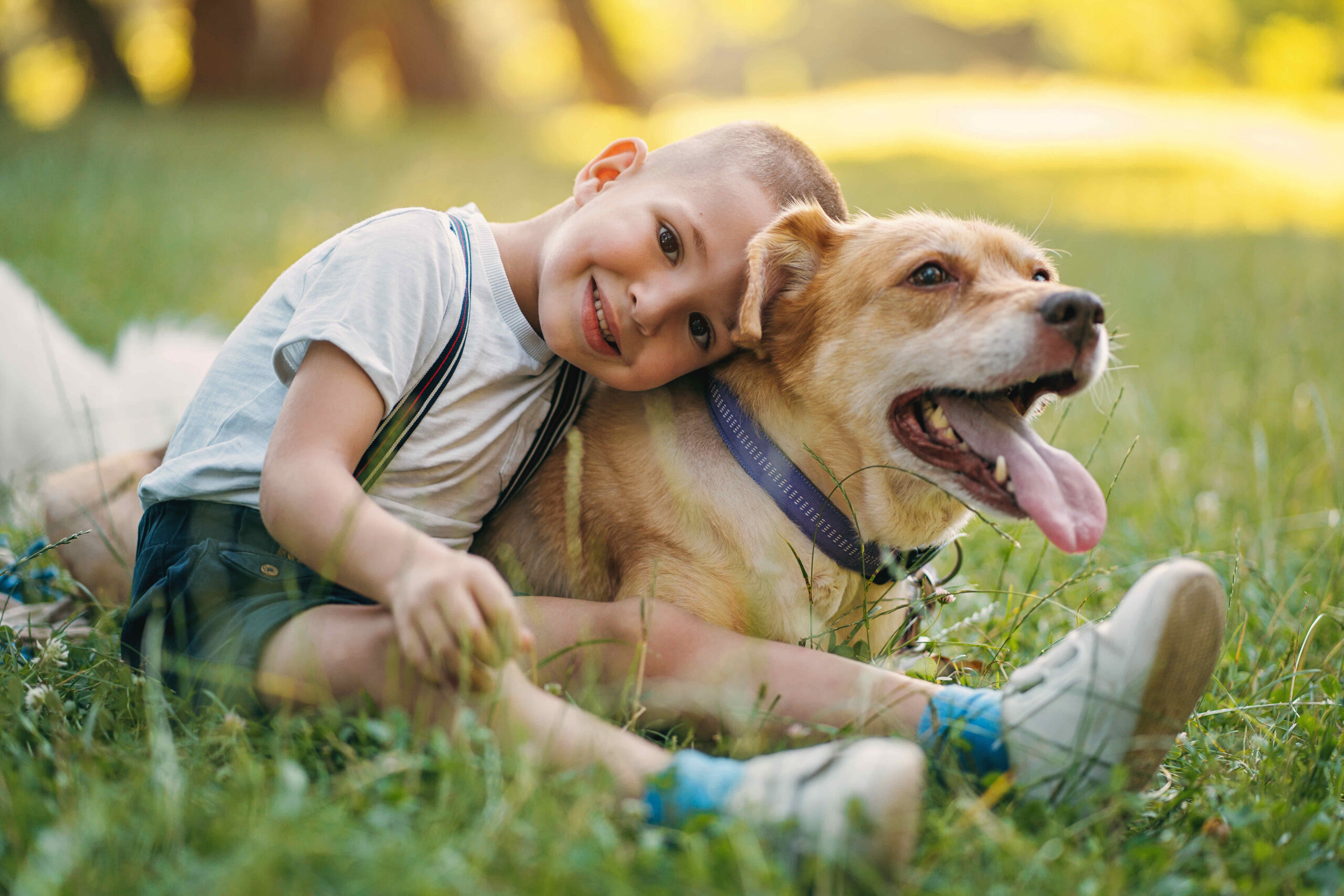 Cute boy cuddling with his dog